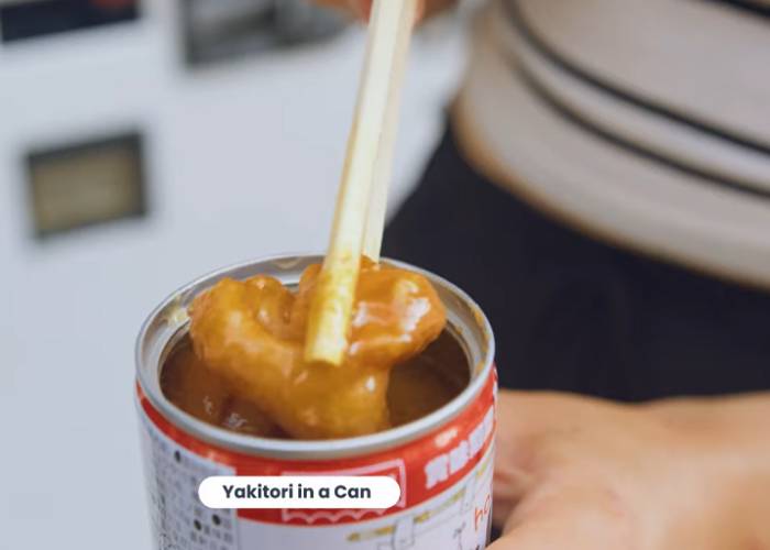 A piece of yakitori being picked from a can by chopsticks. It looks gooey.